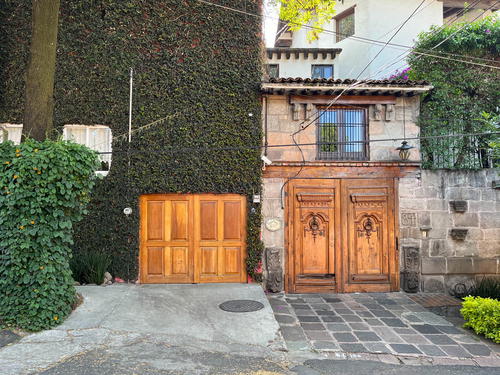 An old house in Mexico City with wooden doors and an ivy covered wall.