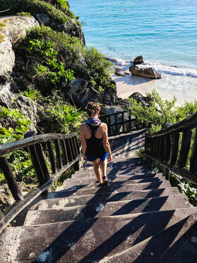 Woman walking down the steps in the Tulum Ruins