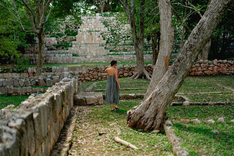 A woman in a green dress explores the jungle in Mexico.