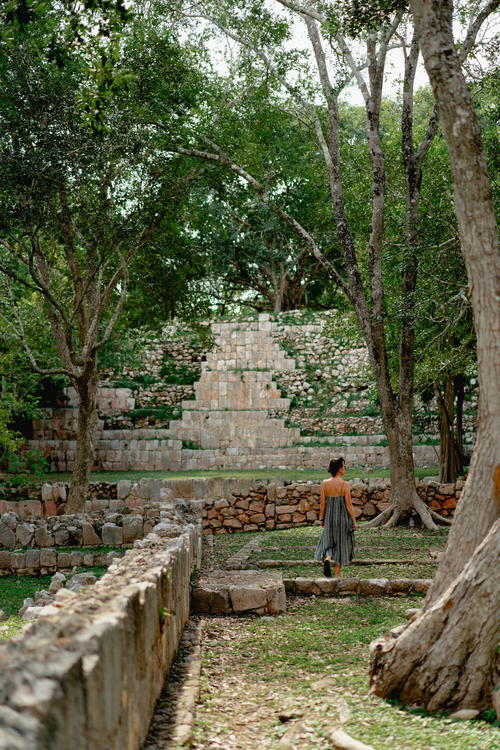 A woman walks down a stone path in Uxmal, Mexico.