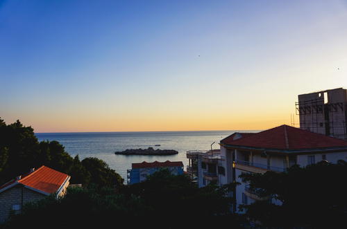 A view of a boat in the water at sunset in Budva