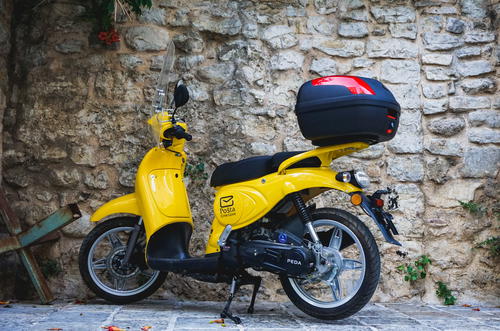 A yellow scooter with a helmet on top of it