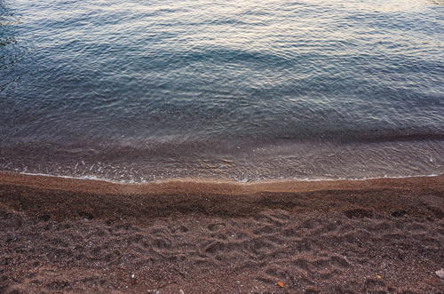 A body of water sitting next to a sandy beach