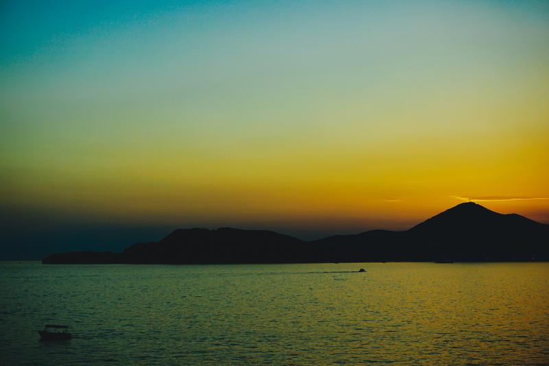 A boat is out on the water at sunset
