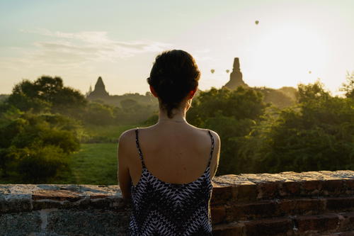 Woman at Mimalaung Kyaung Temple for sunrise view of balloons Bagan Myanmar Burma