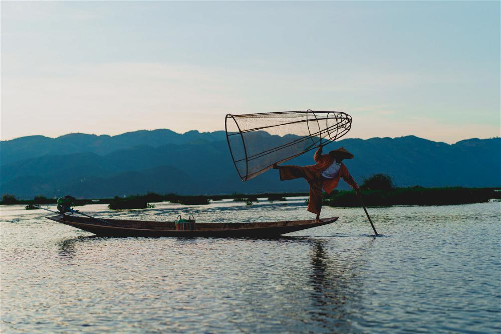 Dancing fishermen standing on one foot at Inle Lake Myanmar