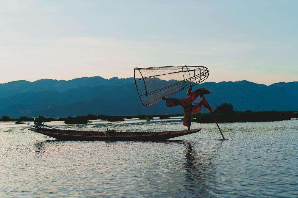 Dancing fishermen standing on one foot at Inle Lake Myanmar