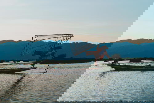 Dancing fishermen standing on one foot at Inle Lake Myanmar