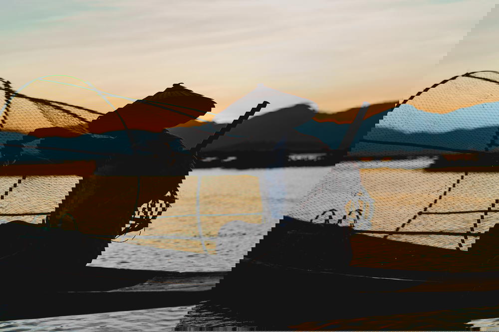 Iconic dancing fisherman of Inle Lake Myanmar holding up a fish for a photo