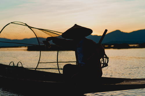 Dancing fishermen; Sunset with dancing fisherman at Inle Lake Myanmar