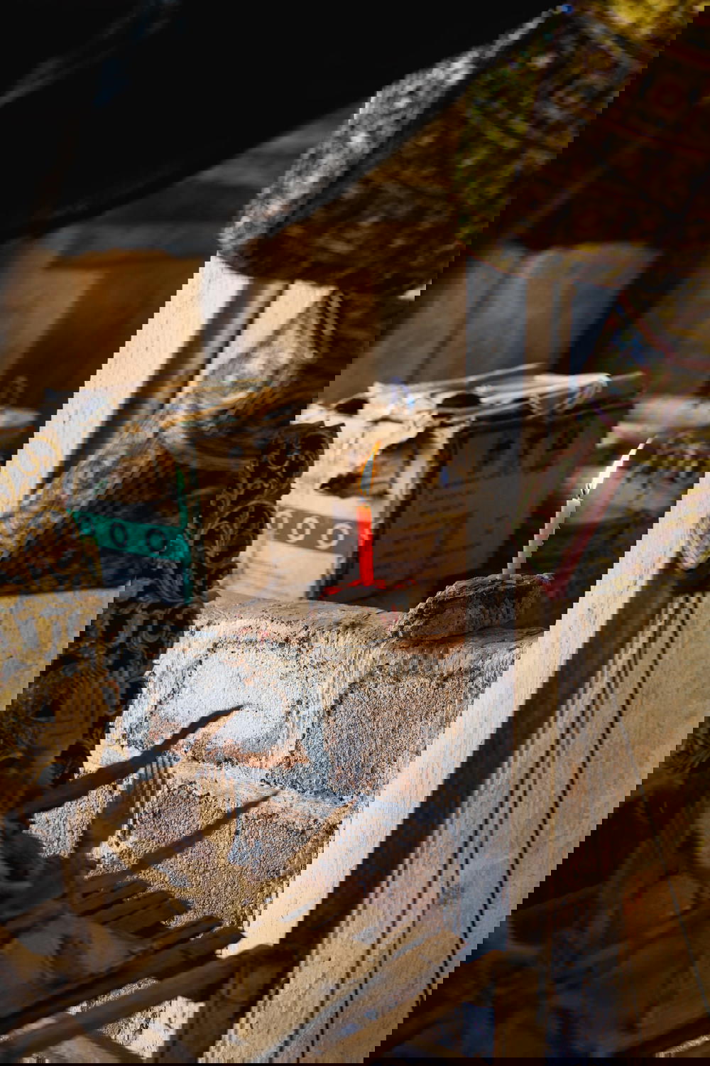 Candle burning on a cinder block wall in the back of a town market in rural Myanmar