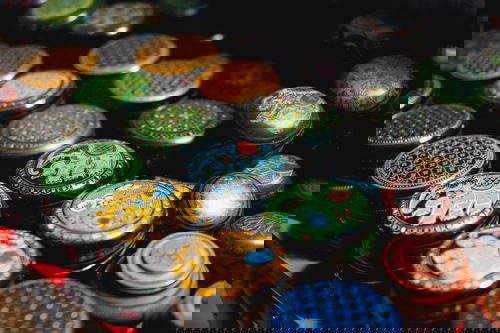 A group of colorful tin cans on a table inspired by Indian aesthetics.