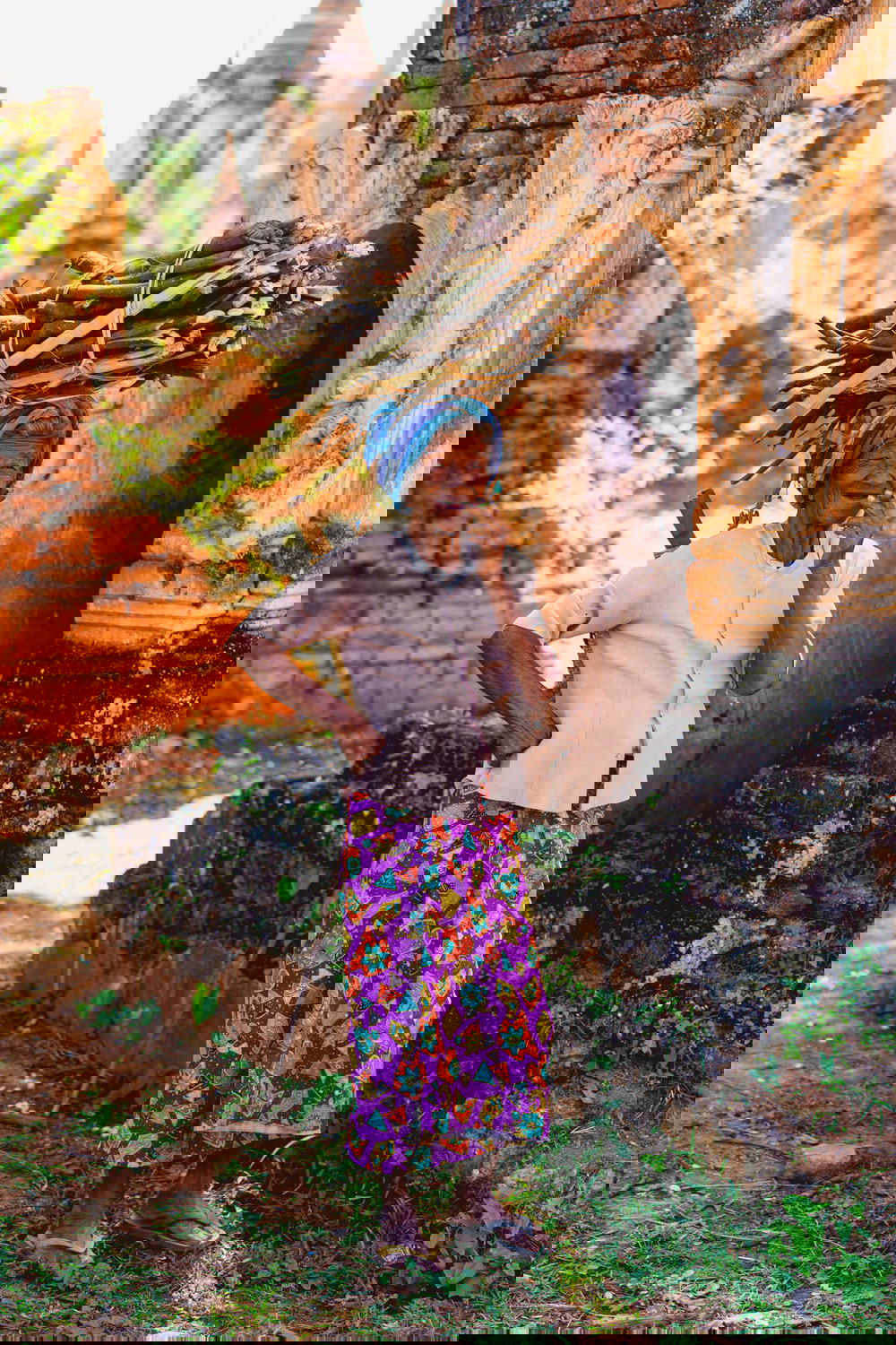 Portrait of an old Burmese ethnic minority tribal woman in a field of ancient stupas in Indein Myanmar