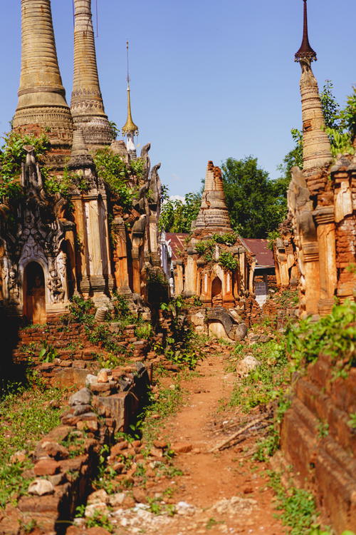 A dirt path leading to an Indian temple.
