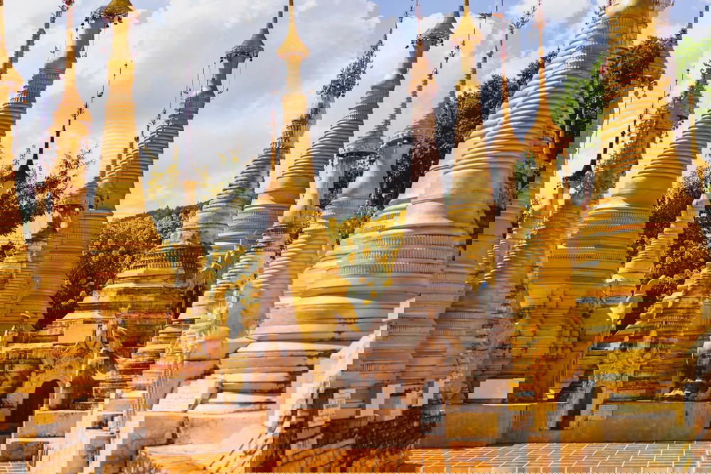 Tall golden and white stone pagodas at the buddhist temple of Indein Myanmar at Inle Lake