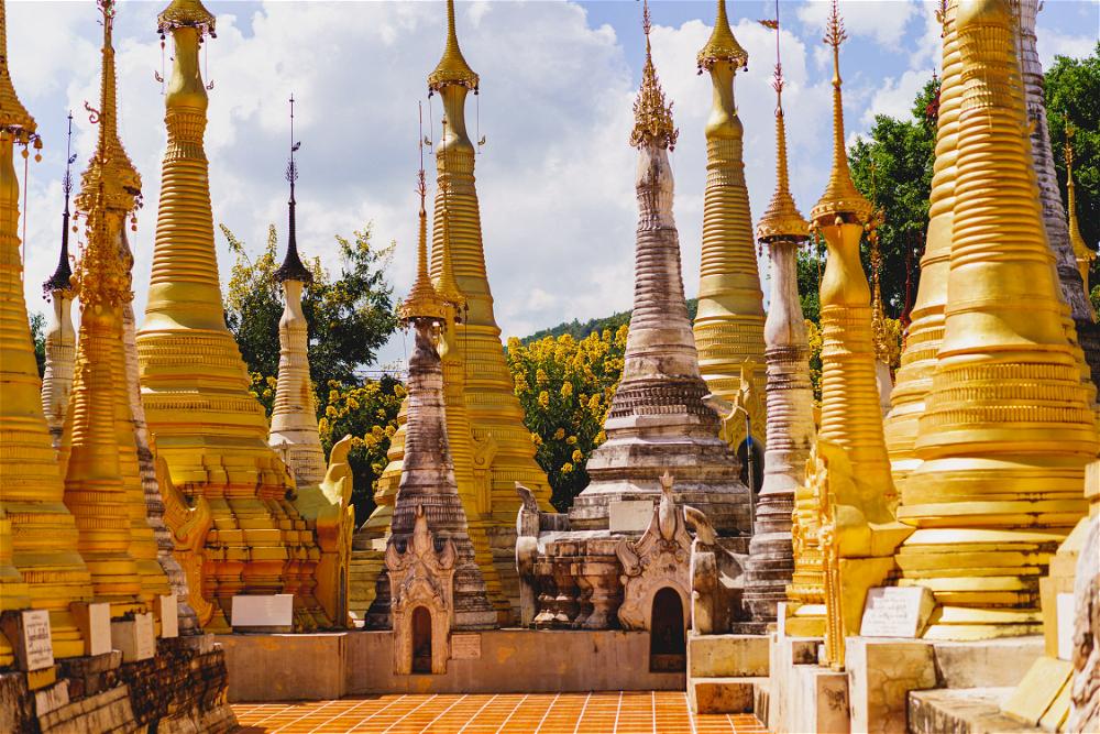 Tall golden and white stone pagodas at the buddhist temple of Indein Myanmar at Inle Lake