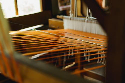 A weaving loom with orange threads found at Inle Lake, Myanmar.