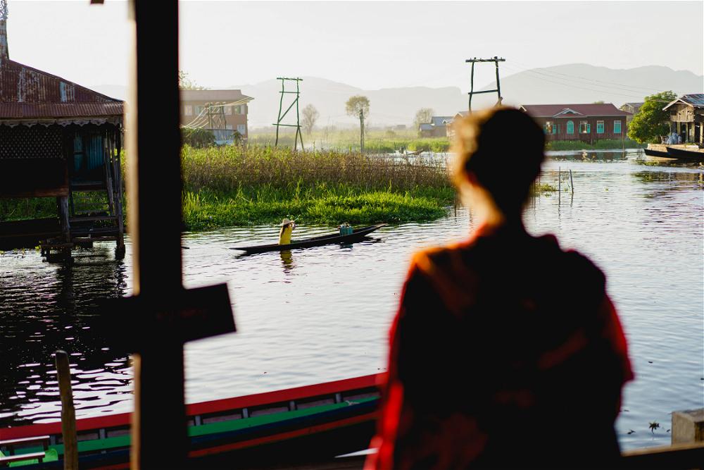 A woman admiring Inle Lake from a window.