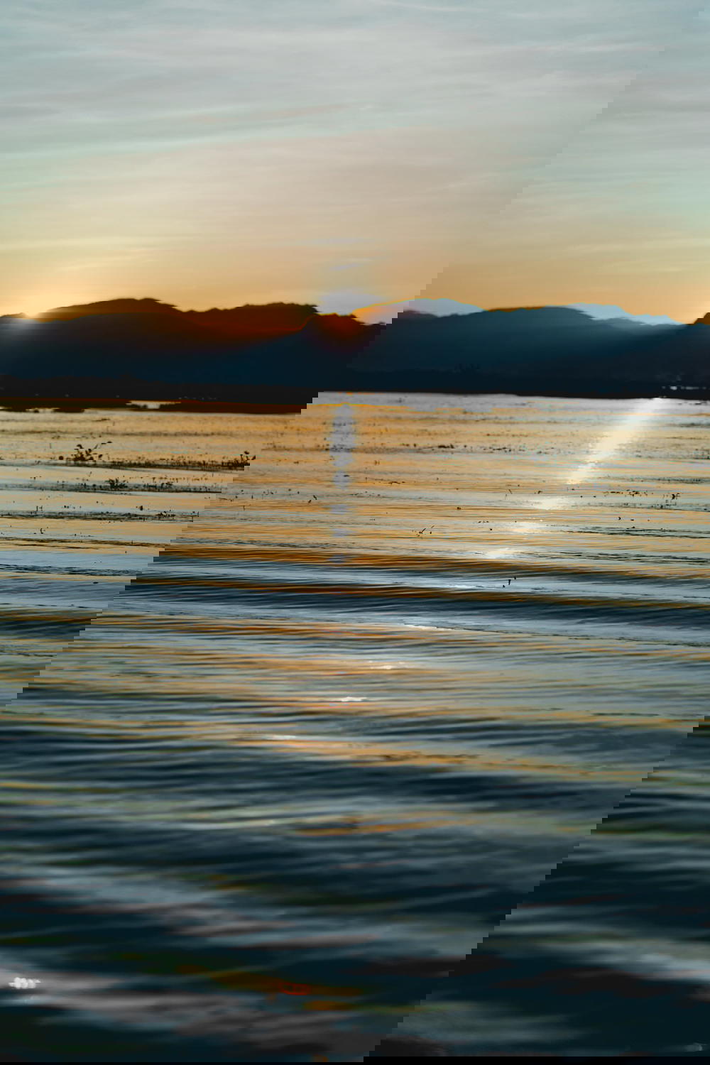 Sunset reflecting in the water along a mountain range at Inle Lake Myanmar