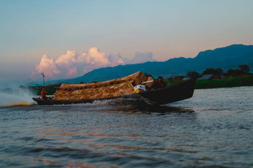 A small boat is traveling down Inle Lake in Myanmar (Burma).