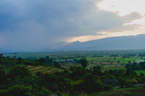 Rain comes over farmland seen from Red Mountain winery at Inle Lake Myanmar