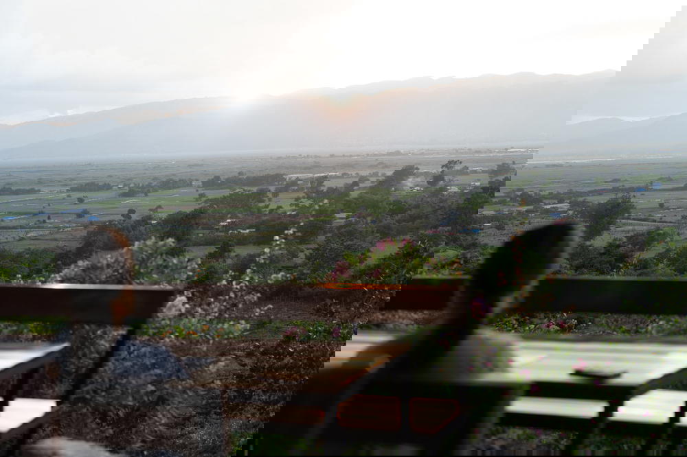 Travelers watch the sunset from wooden picnic tables at the Red Mountain Winery at Inle Lake Myanmar