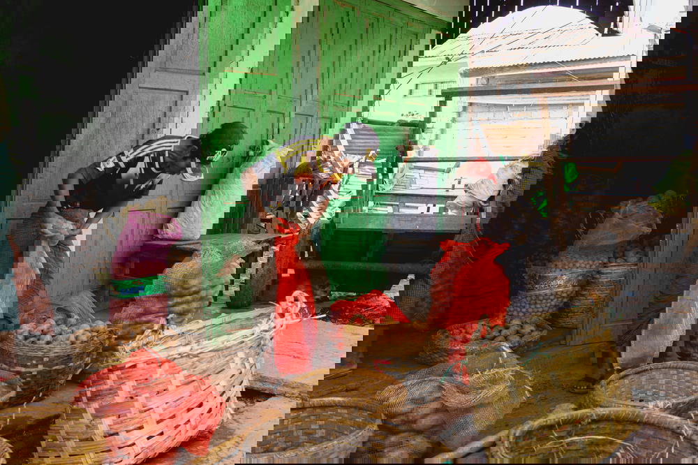 Burmese man shaking bags with woven baskets at village market of Nyaungshwe Myanmar