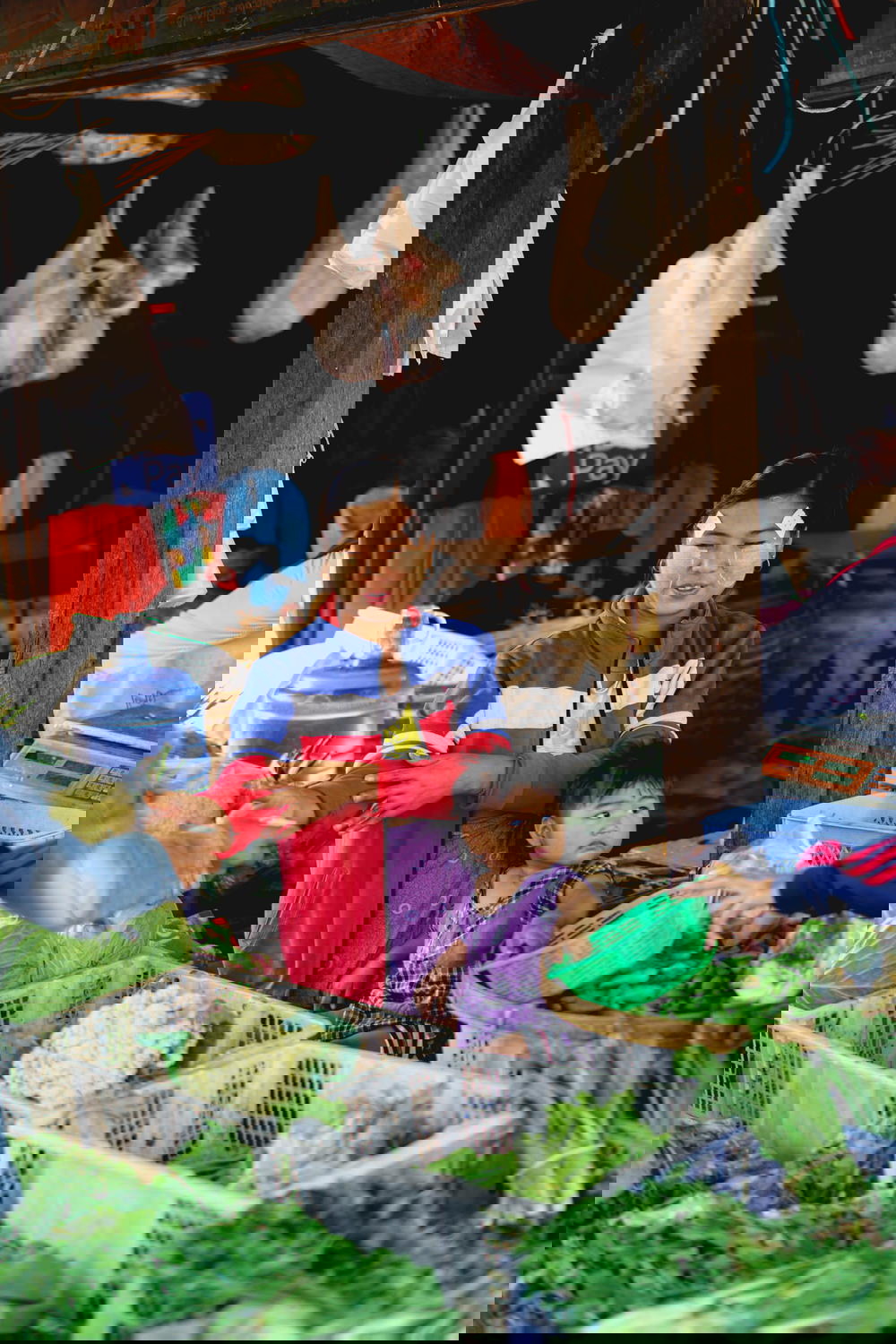 Burmese woman and baby selling fresh produce and greens at village market of Nyaungshwe Myanmar