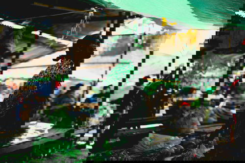 Burmese woman under tarps at Mingalar Market nyuangshwe city Inle Lake Myanmar