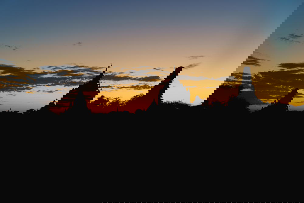 Outlines of Buddhist temples against a vibrant sunrise sky at the national park of Bagan Myanmar