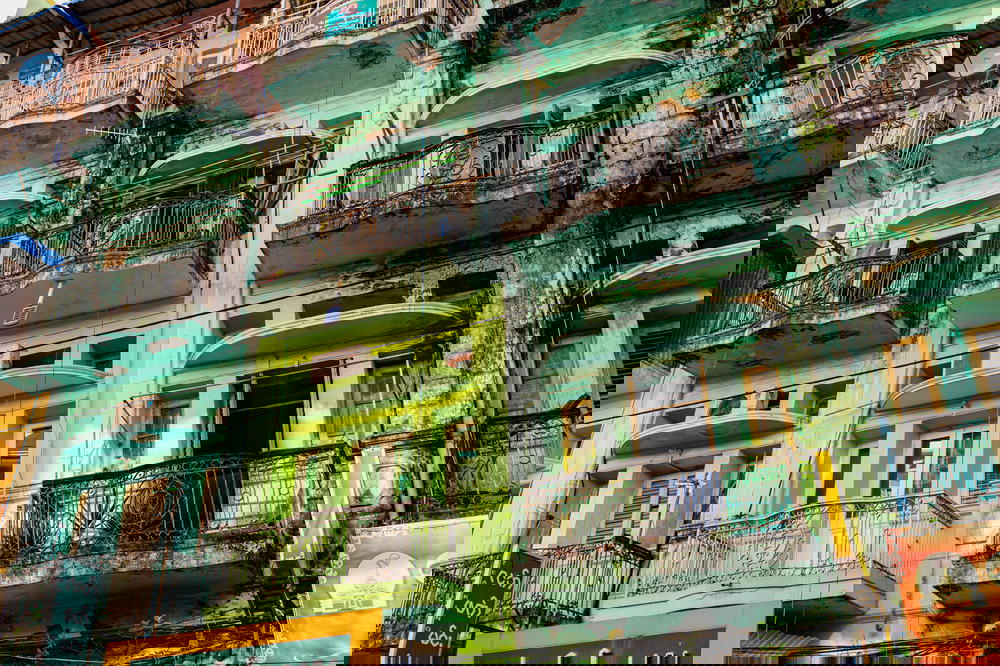 Crowded and old pastel colored building facades with balconies in Chinatown of Yangon Myanmar