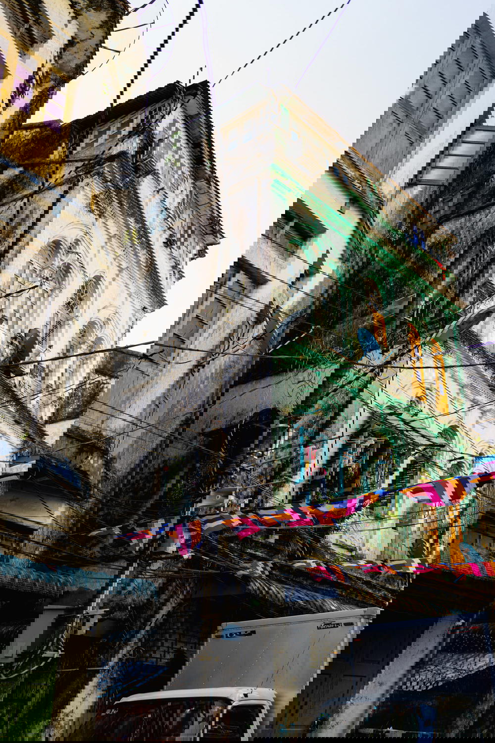 Old colonial architecture on a pastel colored building on a local street in Chinatown of Yangon Myanmar 