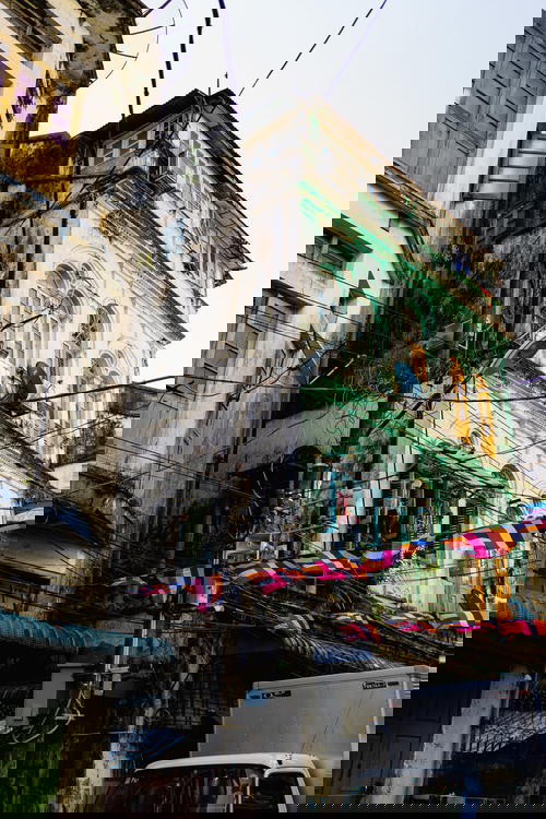 A van is parked in front of a building in Yangon, Myanmar.