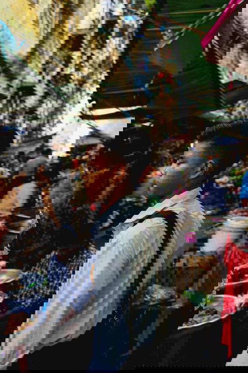 A man navigating through a bustling market in Yangon, Myanmar (Burma).