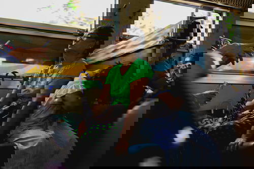 A group of people sitting on a train in Myanmar.