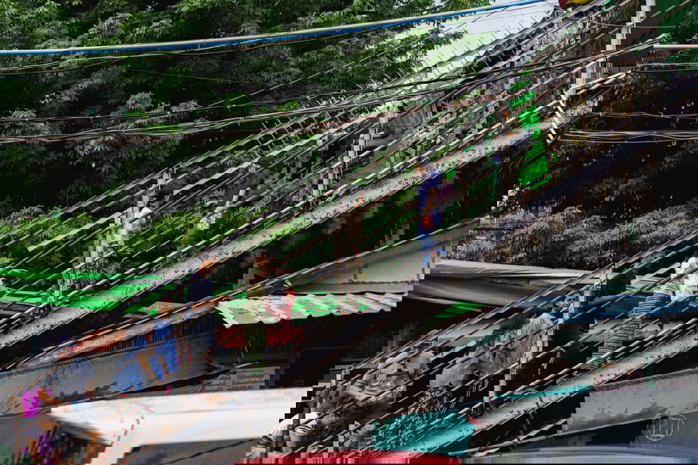 Burmese locals walking down a stairwell of an elevated pedestrian walkway at a crossroads in Yangon Myanmar