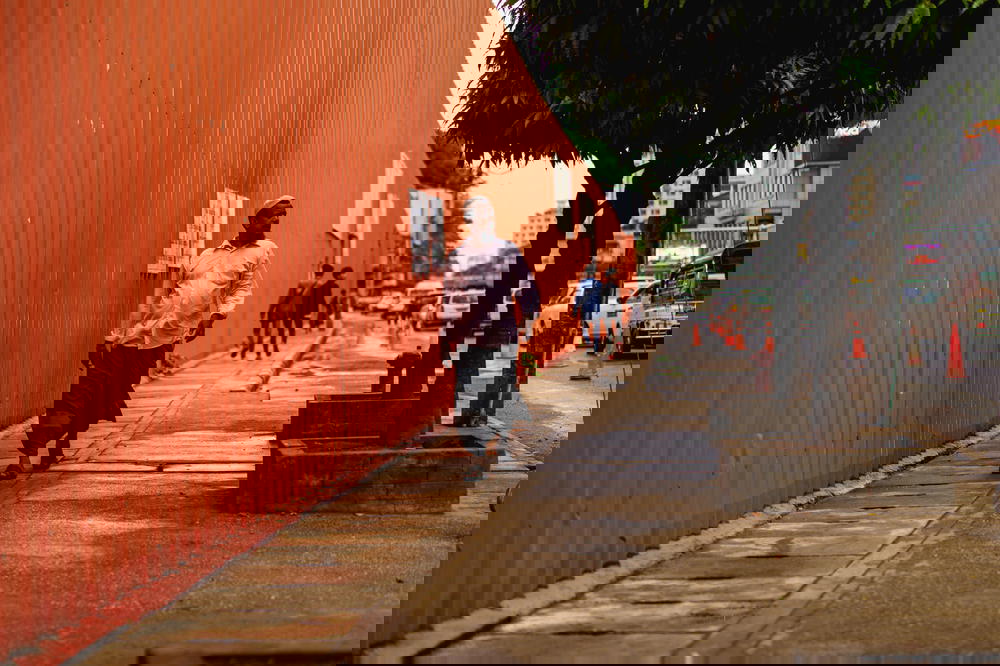 Men in longyi walking past a construction site in downtown Yangon Myanmar