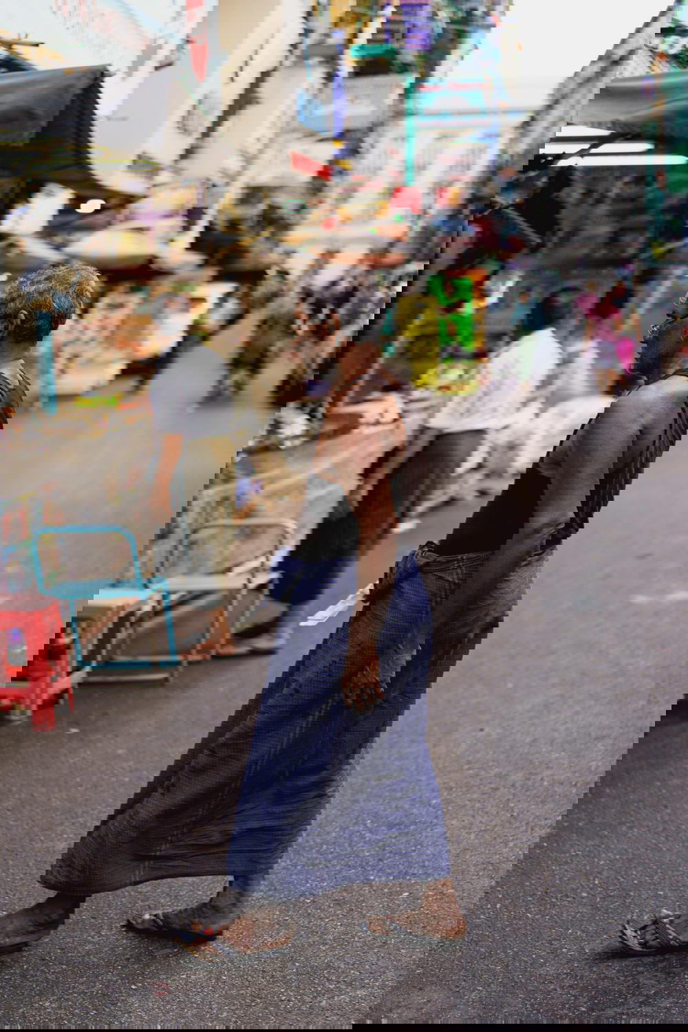 Local Burmese man wearing traditional dress of a longyi in downtown Yangon Myanmar