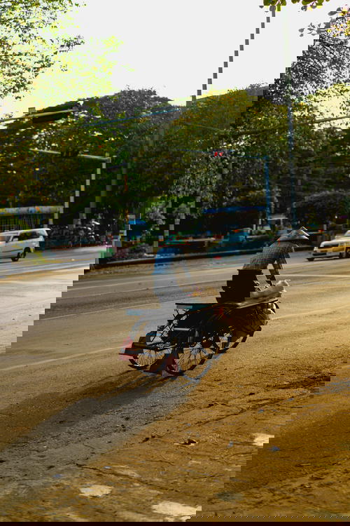 A man cycling along a street in Yangon, Myanmar.