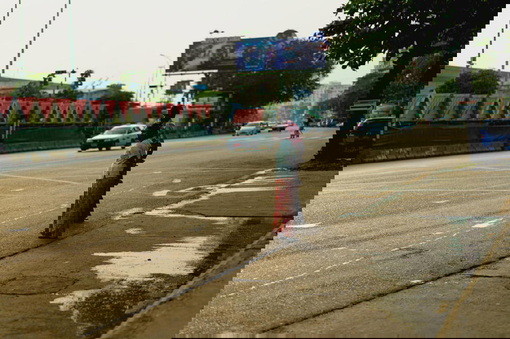 Indian Burmese locals wait to cross the street at a busy road in Yangon Myanmar