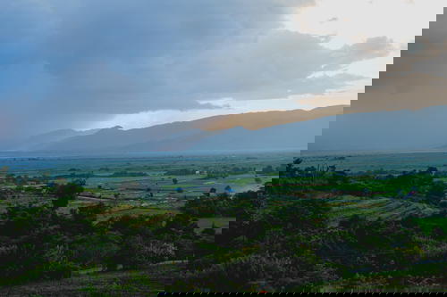 Rain comes over farmland seen from Red Mountain winery at Inle Lake Myanmar