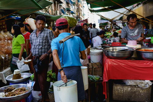 Man with goods in local street market, Yangon