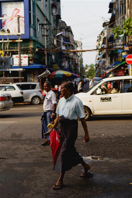 Man wearing longyi walking in Yangon, Myanmar