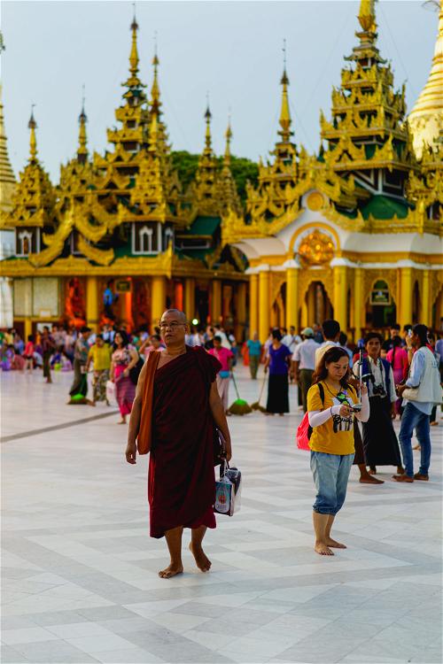 Monk walking at Shwedagon Pagoda, Yangon, Myanmar at sunset