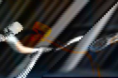 A bicycle handlebar with a yellow light on it, commonly seen in The Netherlands.