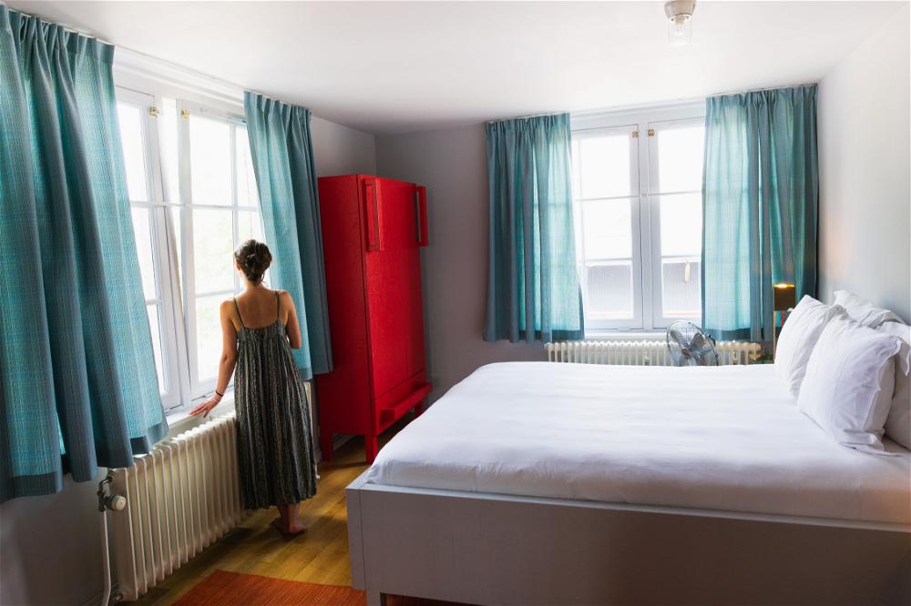 A woman standing in a room at The Lloyd Hotel in Amsterdam.