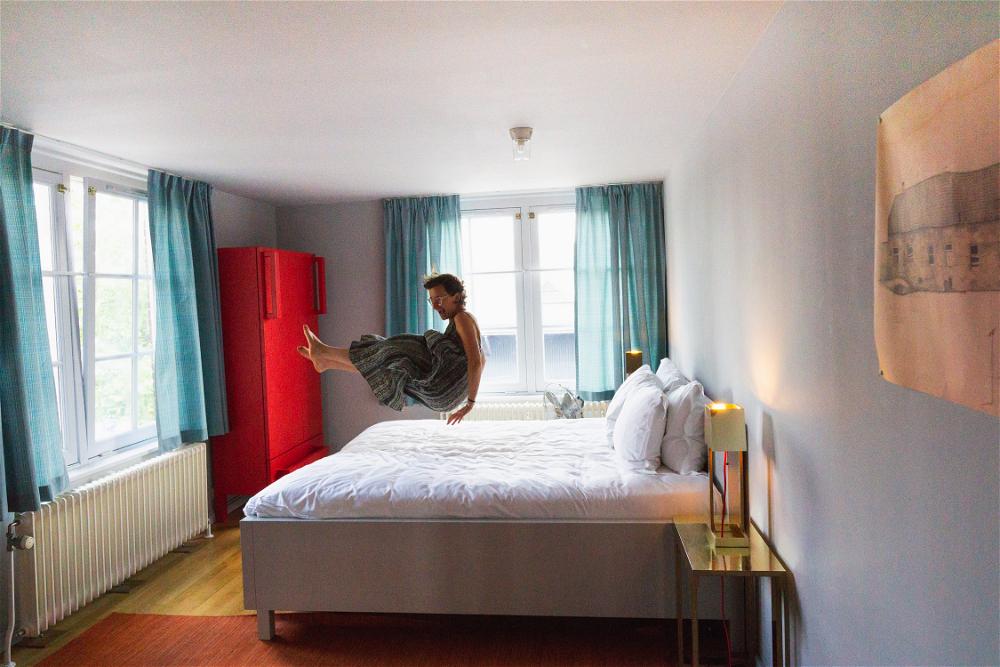 A person jumping on a bed at The Lloyd Hotel in Amsterdam, The Netherlands.