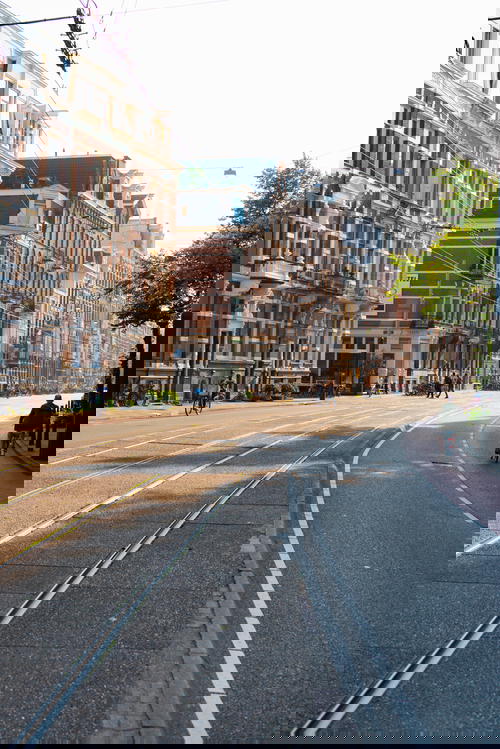 A city street in Amsterdam with distinct Dutch architecture.