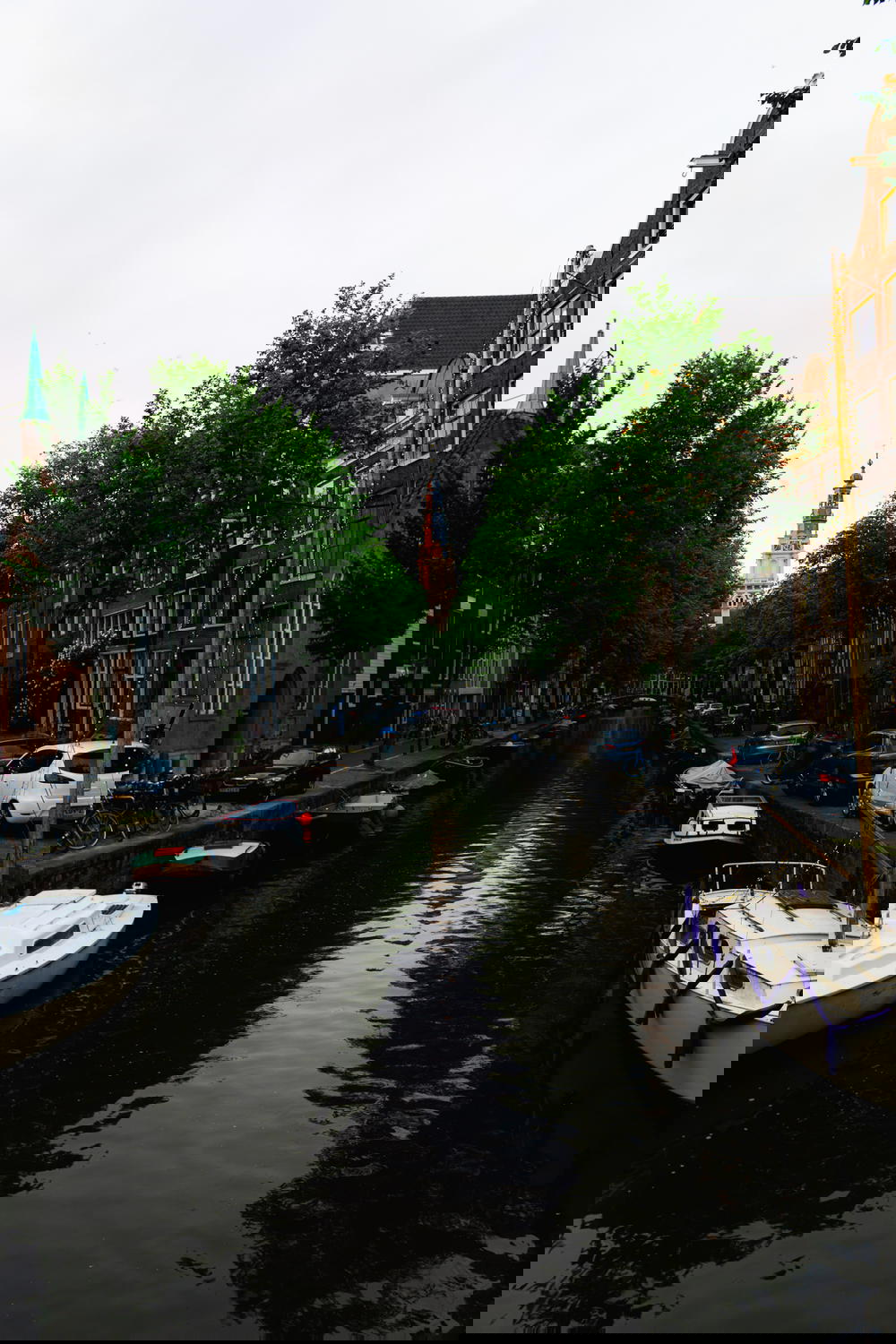 An Amsterdam canal showcasing Dutch architecture with boats.