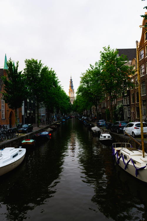 An Amsterdam canal showcasing Dutch architecture with boats.